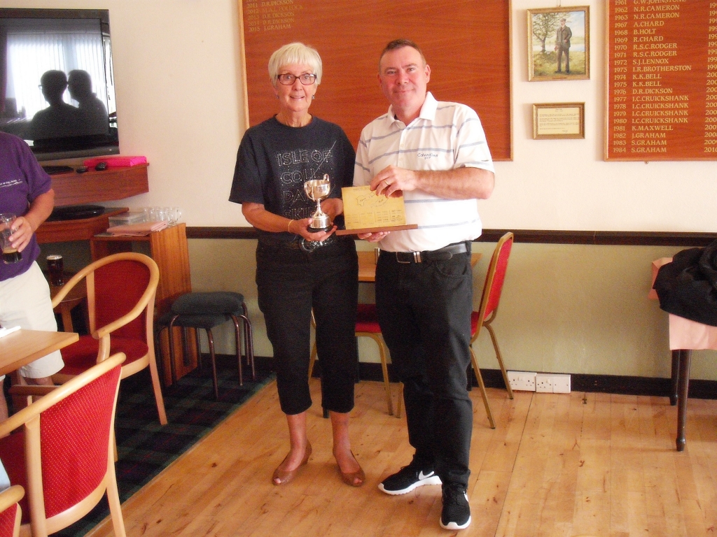 Mr Alistair Water of the Tiree team accepts the Oban Times Cup and the Coll-Tiree plaque from Mrs Margaret Thorburn